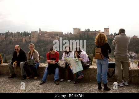 Touristen genießen den Blick auf den maurischen Alhambra-Palast vom Mirador San Nicolas im Stadtteil El Albayzín oder Albaicín Stockfoto