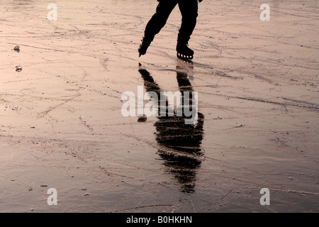 Eis-Skater in Schlittschuhen spiegelt sich in der gefrorenen Oberfläche von den Fluss Havel, Potsdam, Deutschland, Europa Stockfoto