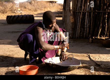 Massaifrau, waschen sich vor ihrem Haus in einem Dorf in der Nähe von Dodoma in der Boma-Region, Rofati, Tansania. Stockfoto