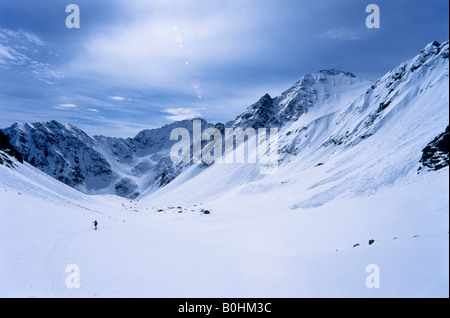 Winzige Figur ein Tourengeher in einem verschneiten, breite hohe Hochtal, Stubaier Alpen, Tirol, Austria, Europe Stockfoto