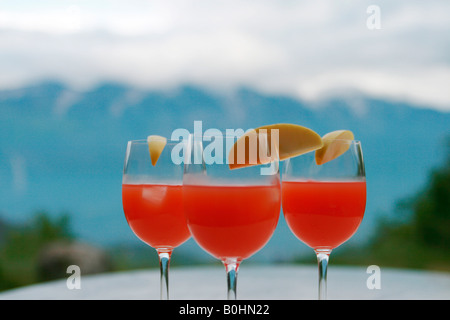 Drei rote Cocktails vor dem Bergpanorama Stockfoto