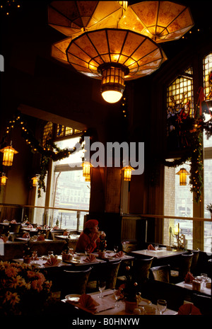 Eine Frau sitzt alleine im Restaurant des American Hotel, Amsterdam, Niederlande. Stockfoto