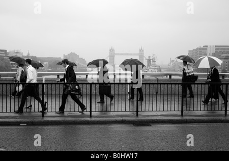 Pendler, die London Brücke während eines nassen morgendlichen Berufsverkehr, London Stockfoto