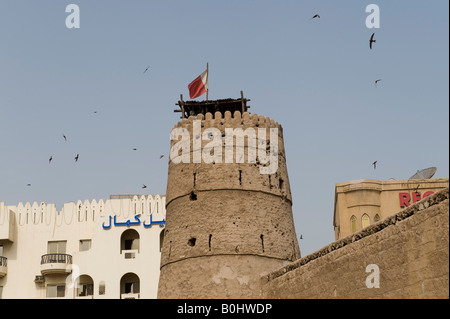 Dubai, Vereinigte Arabische Emirate (VAE). In der Altstadt von al Bastakiya, Schwalben Kreis der Turm von Al Fahidi Fort (1787) und das Dubai Museum Stockfoto