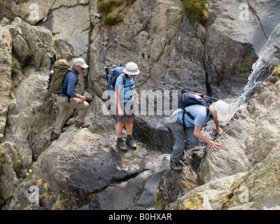 Idwal Nord-Wales-UK-Gruppe von Menschen zu Fuß auf Weg Kreuzung felsigen Stream im Gully in Snowdonia "Nationalpark" Stockfoto