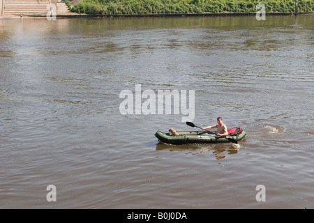 Mann in aufblasbares Kanu paddeln unter Chiswick Bridge, während ein Hund im Bug sitzt Stockfoto