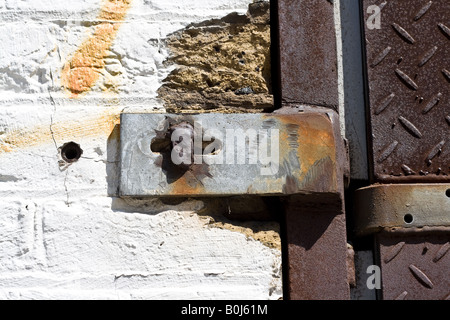 Nahaufnahme der weiß bemalte Ziegel Wand und eisernen Tür. Stockfoto