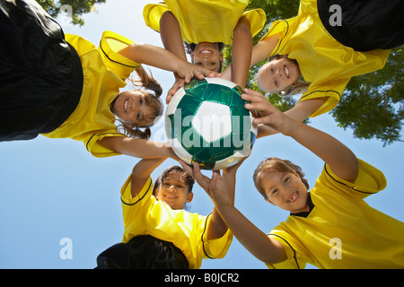 Fünf Kinder (7-9 Jahre) halten Fußball, Ansicht von unten, Porträt Stockfoto