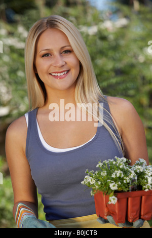 Porträt der Frau mit Blumen im Garten Stockfoto