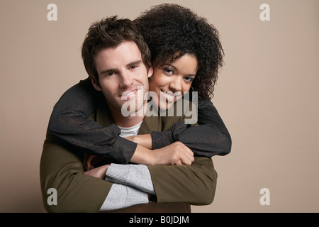 Junges Paar, Frau umarmen Mann von hinten, Porträt Stockfoto