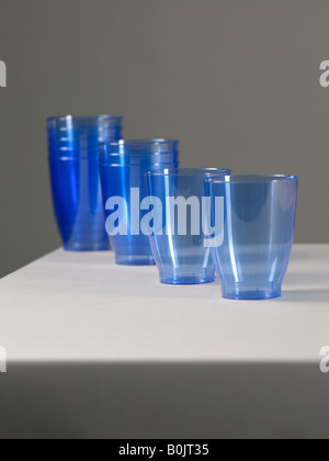 blaue Plastikbecher auf grauem Hintergrund Stockfoto