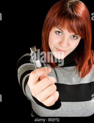 Schöne rothaarige Mädchen hält einen USB-Stick oder USB-Stick an der Kamera Studioaufnahme Stockfoto