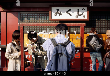 7. November 2004 - binden Anbeter Omikuji (Glück Papiere) zu einem Stall in Senso-Ji-Tempel (Kinryū Zan Sensō-Ji) in Tokios Asakusa. Stockfoto