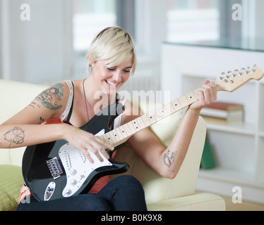 Junge Frau spielt e-Gitarre Stockfoto