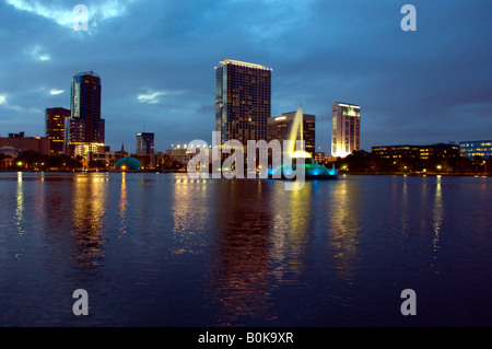 Die Skyline der Innenstadt von Orlando Florida spiegelt sich in der Abenddämmerung in Lake Eola Stockfoto