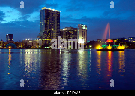 Die Skyline der Innenstadt von Orlando Florida spiegelt sich in der Abenddämmerung in Lake Eola Stockfoto
