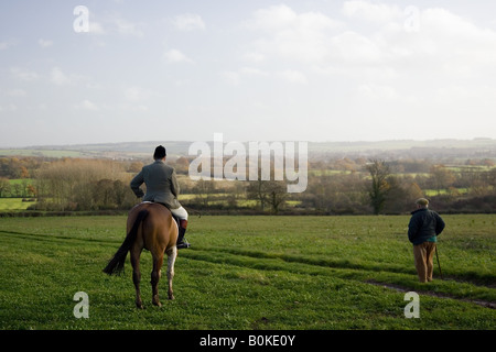 Fahrer bewundert weit reichende Aussicht mit Walker The Cotswolds Oxfordshire Vereinigtes Königreich Stockfoto