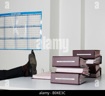 Office Worker Beine auf dem Schreibtisch Stockfoto