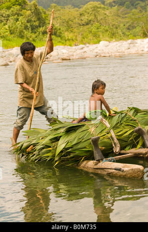 COSTA RICA indigenen Cabecar Indianer Stamm-Vater und Sohn über den unteren Pacuare Fluss auf einem Baumstamm Floß den Transport von Suyta Palm Stockfoto