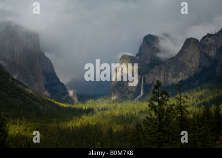 Sonnenlicht und Gewitterwolken über Bridalveil Fall Wasserfall und Wald Yosemite Valley Yosemite Nationalpark, Kalifornien Stockfoto