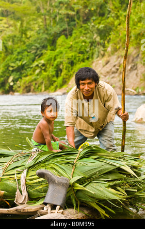 COSTA RICA indigenen Cabecar Stamm Vater und Sohn über den unteren Pacuare Fluss auf einem Baumstamm Floß den Transport von Suyta Palm. Stockfoto