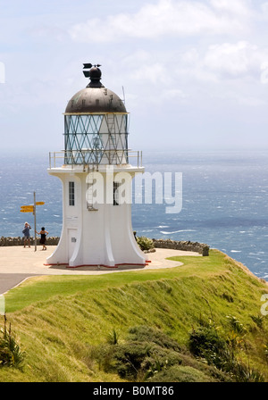 Cape Reinga Leuchtturm mit zwei Touristen, die ein Foto machen Stockfoto