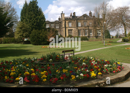 Bramley Grange College in einer Parklandschaft mit Bäumen, Blumen und einer Bank auf der Main Street in Burley in Wharfedale Stockfoto