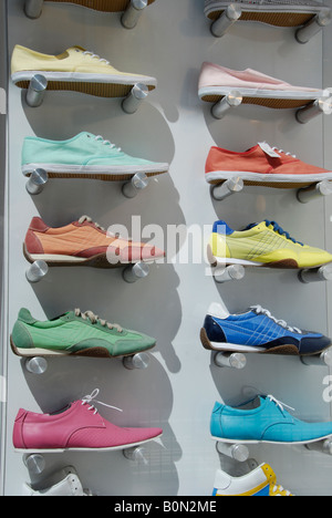 Zahlreiche bunte Sneaker Art Schuhe im Schaufenster anzeigen in London High Street Stockfoto