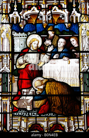 Glasfenster mit der Darstellung von Maria, die die Füße Jesu wäscht, Kirche St. Fabian & St. Sebastian, Woodbastwick, Norfolk Stockfoto