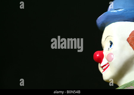 Seitenansicht von einem Spielzeug Clown Gesicht vor einem dunklen Hintergrund Stockfoto