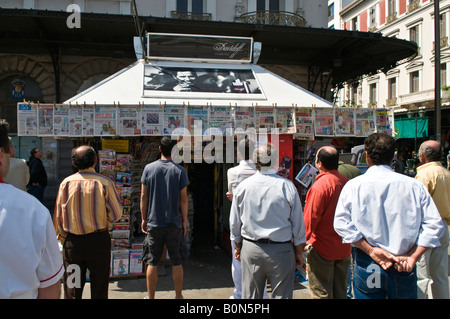 Leute lesen die Schlagzeilen auf Zeitungen oberhalb einer Periptero News-Kiosk in Omonia-Platz, Athen, Griechenland Stockfoto