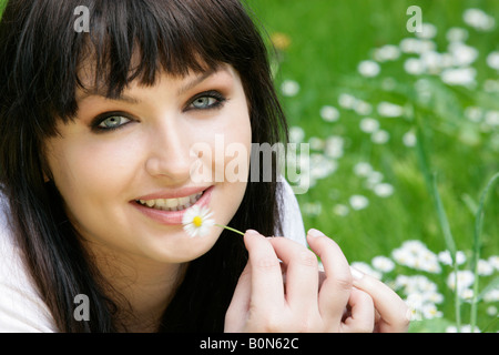 Frau mit Gänseblümchen im Rasen liegen Stockfoto