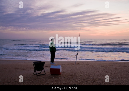 Rentner, Angeln am Meer mit seinem Kühler und Leinwand Klappsitz bei Sonnenaufgang in Ponte Vedra Beach, Florida, USA Stockfoto