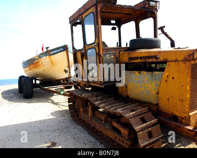 eine rostige alte Traktor und Boot am Strand von Weybourne, Norfolk, Großbritannien. Stockfoto