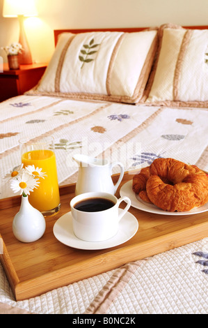 Fach auf ein Bett in einem Hotelzimmer mit Frühstück Stockfoto