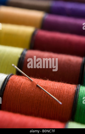 verschiedene Farben der Baumwolle Reelsin eine Zeile mit einer Nadel Stockfoto