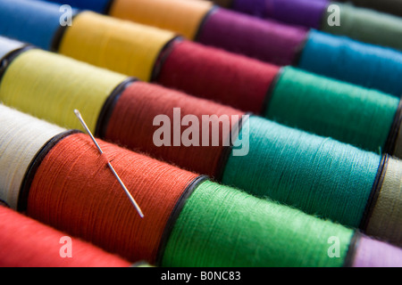 verschiedene Farben der Baumwolle Reelsin eine Zeile mit einer Nadel Stockfoto