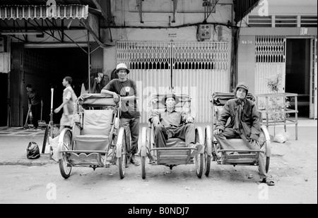 24. Januar 2003 - drei Rikscha-Besitzer genießen Sie einen ruhigen Moment in einer Straße von der kambodschanischen Hauptstadt Phnom Penh. Stockfoto