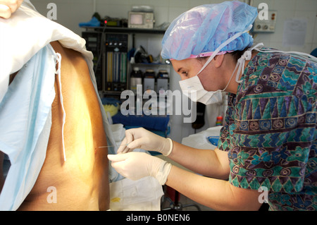 Eine Krankenschwester Anästhesisten verwaltet eine spinale Injektion während der Vorbereitung eines Patienten für die Operation während einer 2006 chirurgischen Mission nach Sula Stockfoto