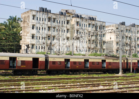 Ein Zug in eine spielt mit einem heruntergekommenen Gebäude im Hintergrund. Die Szene ist im Süden Indiens in der Nähe von Bombay oder Mumbai. Stockfoto