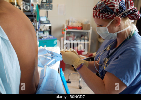 Eine Krankenschwester Anästhesisten verwaltet eine spinale Injektion während der Vorbereitung eines Patienten für die Operation während einer 2006 chirurgischen Mission nach Sula Stockfoto