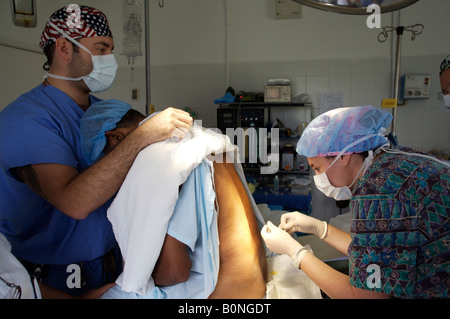 Eine Krankenschwester Anästhesisten verwaltet eine spinale Injektion während der Vorbereitung eines Patienten für die Operation während einer 2006 chirurgischen Mission nach Sula Stockfoto