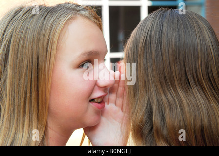 Zwei junge Mädchen im Teenageralter Klatsch auf Schulhof Stockfoto