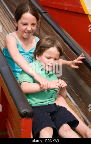 Jungen und Mädchen – Bruder und Schwester – auf der Helter-Skelter schieben an der Richmond nach Themse May Fair. Stockfoto