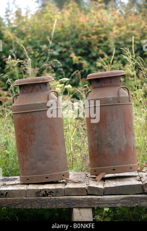 ZWEI ROSTEN MILCHKANNEN AUF EINEM FELDWEG UK Stockfoto