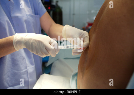 Eine Krankenschwester Anästhesisten verwaltet eine spinale Injektion während der Vorbereitung eines Patienten für die Operation während einer 2006 chirurgischen Mission nach Sula Stockfoto