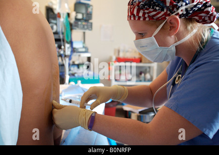 Eine Krankenschwester Anästhesisten verwaltet eine spinale Injektion während der Vorbereitung eines Patienten für die Operation während einer 2006 chirurgischen Mission nach Sula Stockfoto