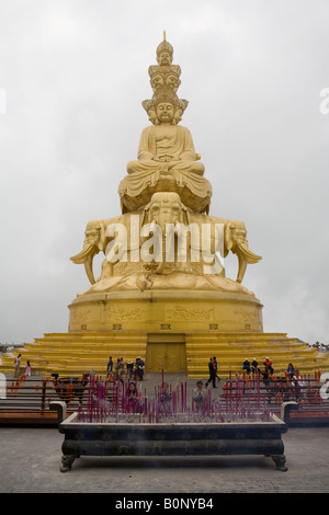 Statue von Buddha sitzt oben auf sechs tusked Elefanten mit in den vorderen Gläubigen bringen Opfergaben Weihrauch facettenreich Stockfoto