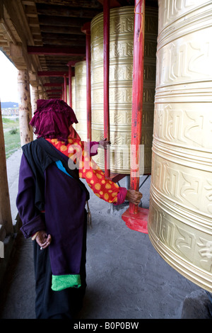 Ältere tibetische Frauen drehen große Gebetsmühlen in buddhistischen Kloster Stockfoto