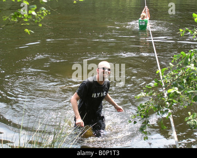 Student überschreiten, fallen im Fluss von Strickleiter Stockfoto